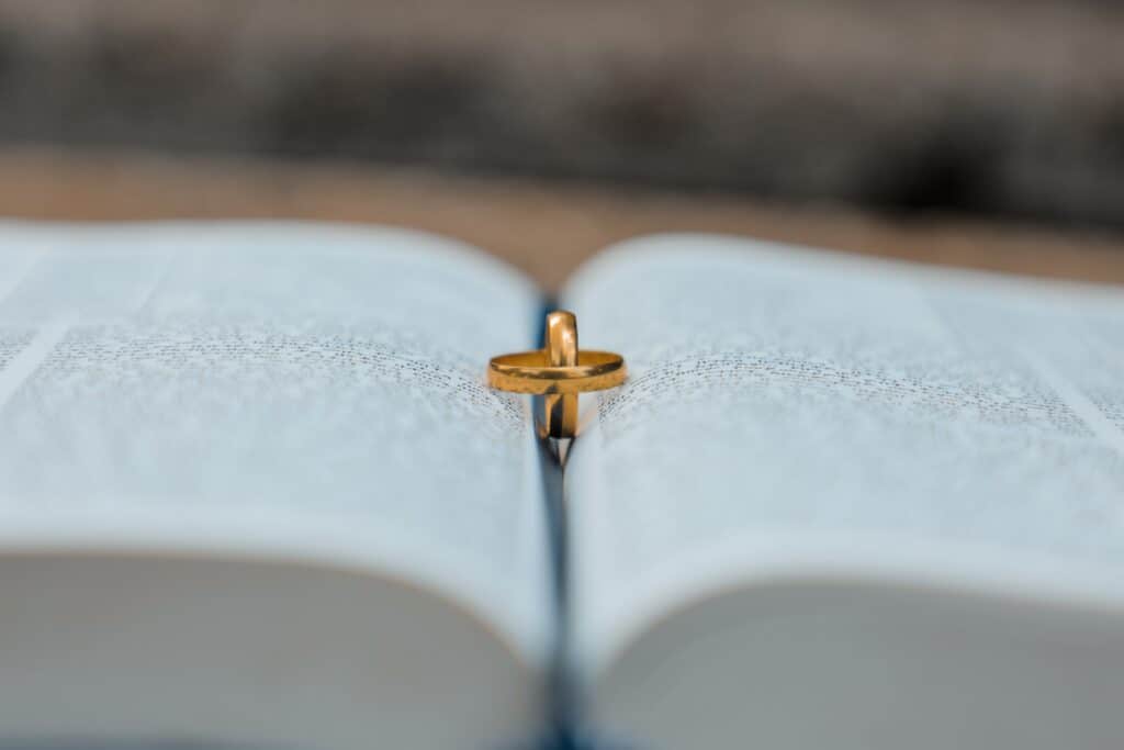 Two gold wedding rings sit on an open book