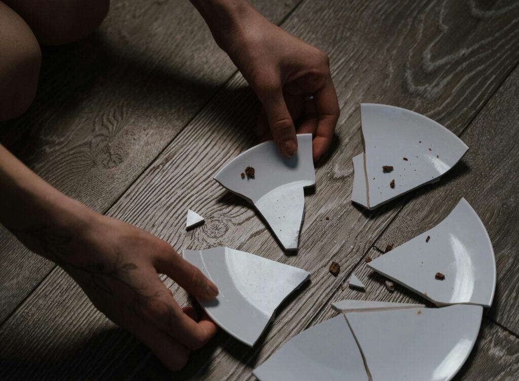 hands near broken plate