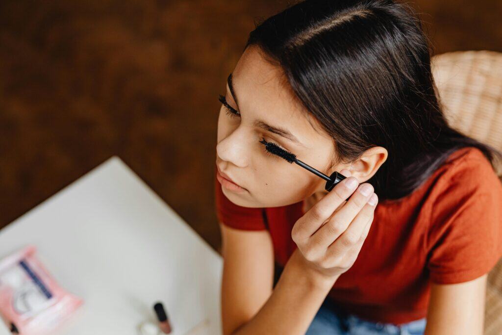 tween girl putting on mascara