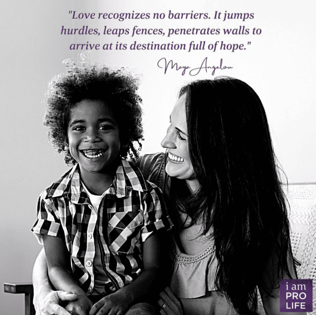 A young woman holds a young boy under a quote about love, hope, and inclusion. "Love recognizes no barriers."