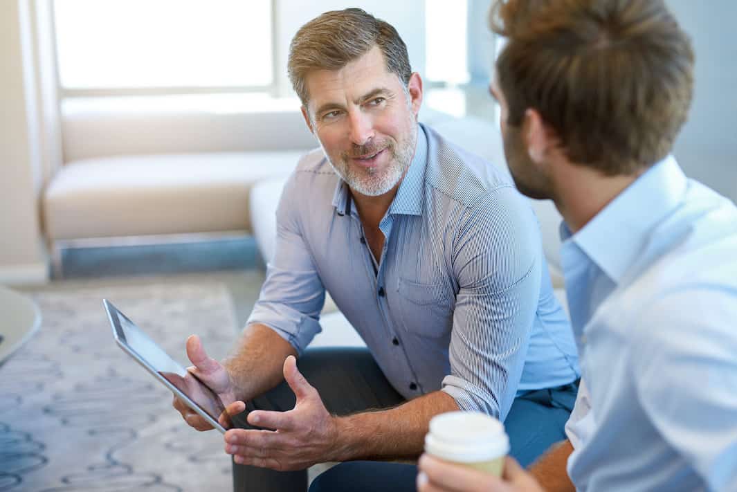 Older man mentoring a younger an.